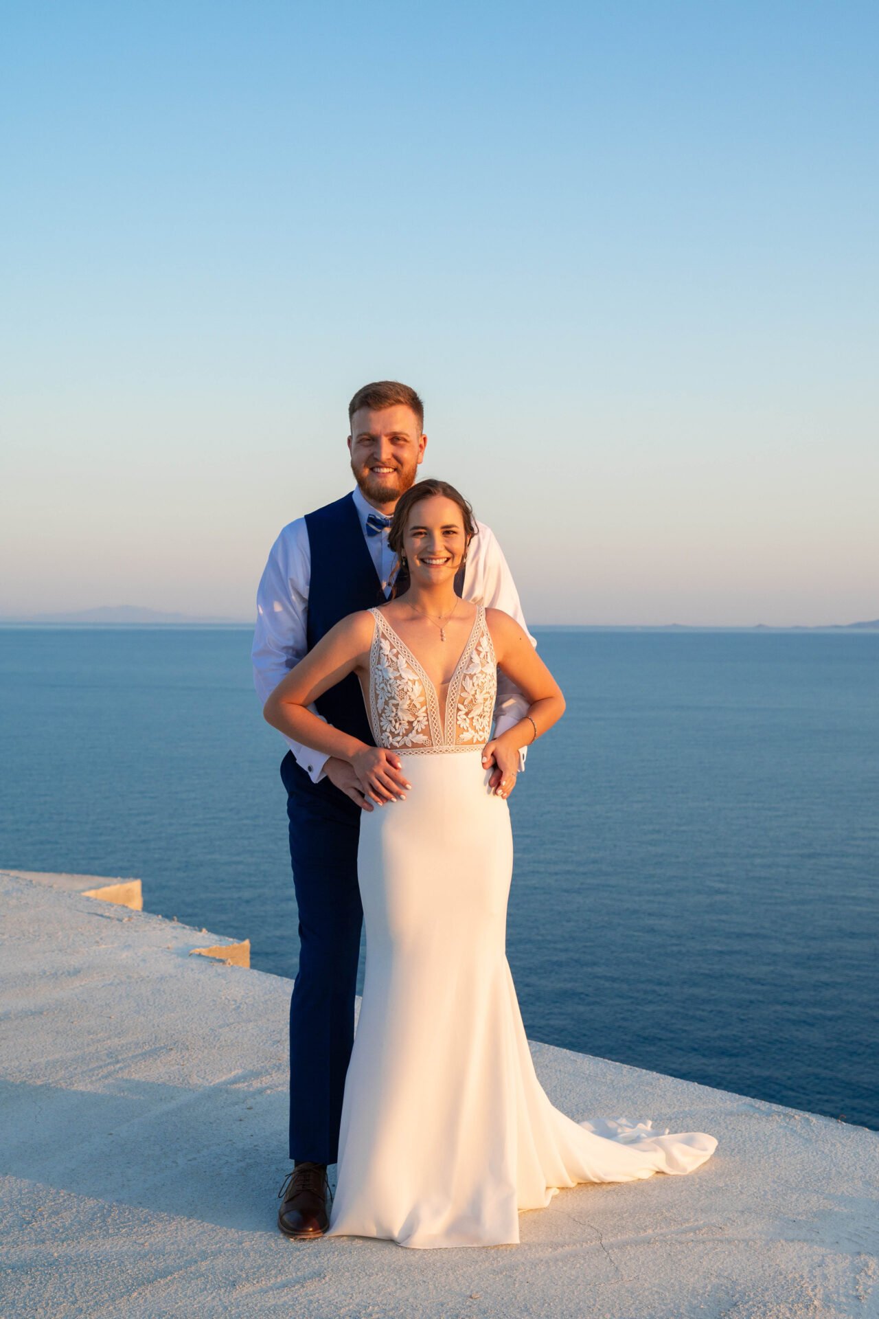 Bride and groom embracing with Aegean Sea views at Vathi Bleu Private Villas, Tinos, Greece.